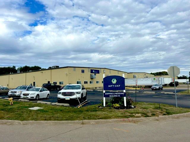 Molded Fiber Technologies' plant exterior colored in yellow with signage showing logo and company name
